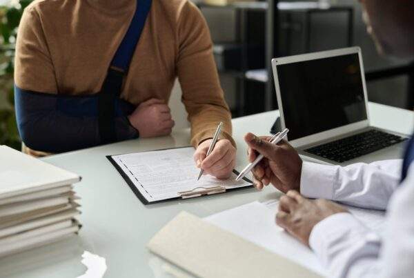 Injured man signing legal paperwork